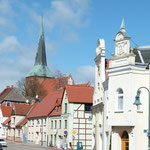 Folgen Sie der Straße, kommen Sie an der rechten Seite an einem Friseur,einem Andenkenlädchen und der Post vorbei,