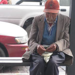 Ein alter Mann an einer Bushaltestelle, der die ganze Zeit Cocablaetter gekaut hat.