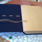 Il laccio di chiusura del quaderno è lo stesso cordino resinato che cuce i tre fascicoli e che impuntura la copertina decorandola