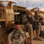 In March 2007, a group of U.S. Army soldiers sit on the rear ramp of an M113, staging for a reconnaissance mission in Forward Operating Base Kalsu, Iraq