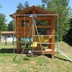 La cabane de jeux avec bac à sable, toboggan, hamac et balançoires