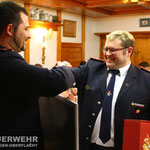 Jugendwart Sebastian Bertelmann übergibt seinem Vorgänger OLM Karl-Wilhelm Lehmann ein Präsent der Jugendfeuerwehr