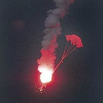 Seenotrakete: Eine rot brennende Magnesiumfackel sinkt langsam an einem Fallschirm hängend zu Boden / © Freiwillige Feuerwehr Cuxhaven-Duhnen