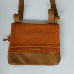21. stof en leer (b 31cm x h.26cm) extra voorvak, sluit met rits. verstelbare schouderband. €60,00