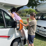 Linda putzt die Autoscheibe und Jan schaut, dass Linda nicht runterfällt