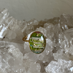 Ring met een stukje textiel, stukjes blad, gouddraad uit een omslagdoek en wat goud nuances. 