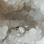 Zilveren ring gevuld met as in een wit parelmoer ondergrond en wat goud accenten 