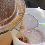 Apfelsaft fliest in einen Eimer