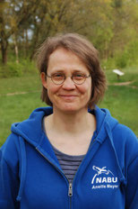 Eine Frau mit kinnlngen braunen Haaren und einer Brille.