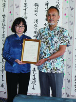 加賀谷陽平部長(右)から藤原さんに任命証が手渡された=30日、市役所市長室