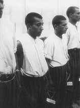 Détenus tsiganes faisant la queue pour l’appel dans le camp de concentration de Dachau. Allemagne, 20 juin 1938.