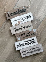 Schild In unserem Zuhause klein braun