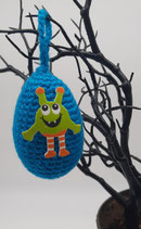 Gehäkeltes Deko-Ei mit aufgeklebtem Monster aus Moosgummi