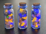 Decoratieve glazen flesje met fluorescerende mineralen mix