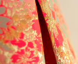 Bild und Button um Zugang zur Untereseite 'Meine Arbeit' zu erhalten. Das Bild zeigt einen vergösserten Ausschnitt einer STofffalte. Der Stoff ist ein mit gold verzierter pinker Jacquard