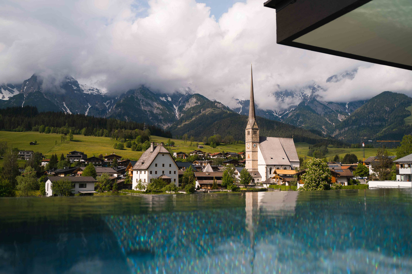 The infinity pool at the Hochkönigin Wellness Hotel in Maria Alm, Salzburg, with views of Maria Alm and the Hochkönig massif