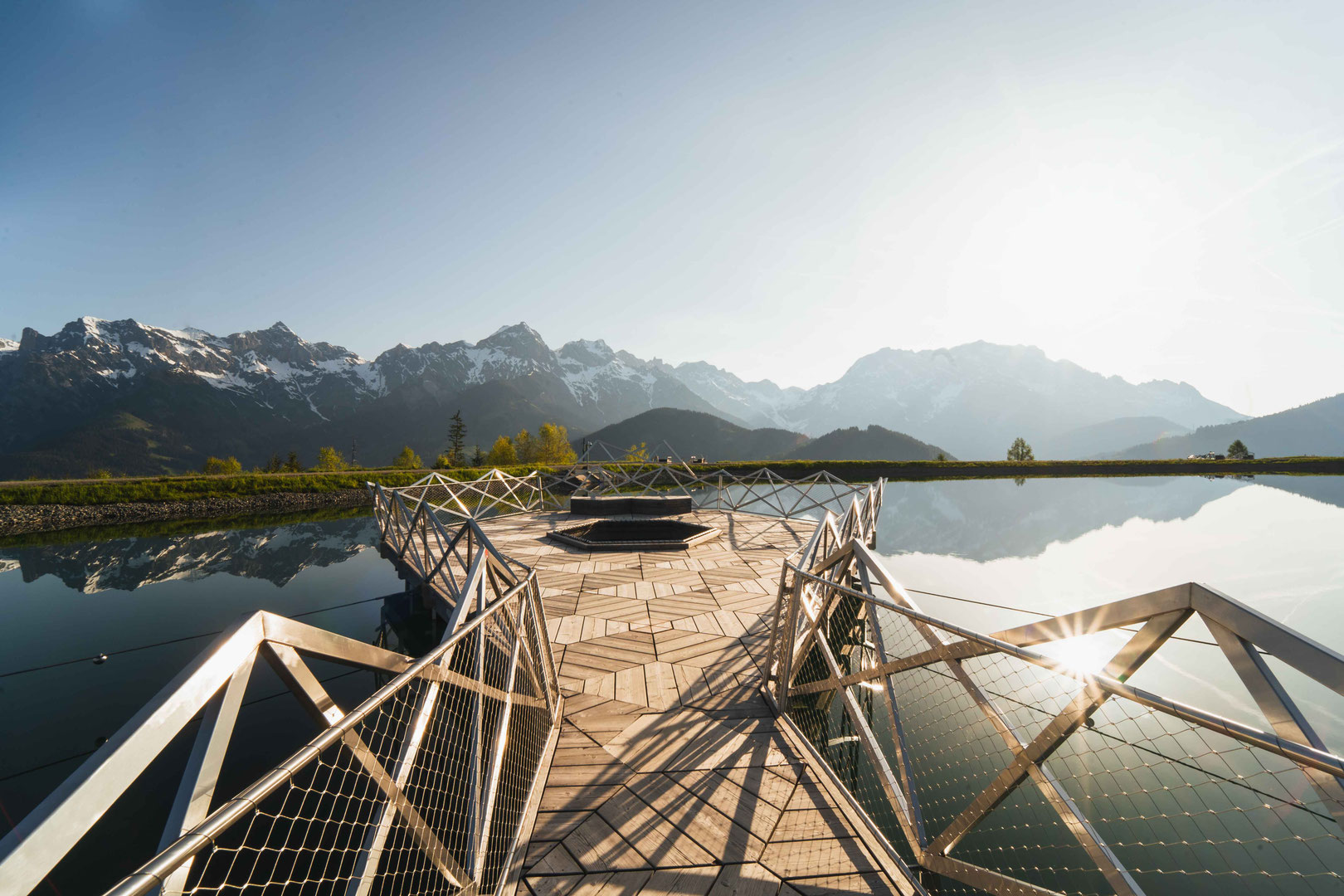 Viewing platform at the natural swimming pond of the Hochkönigin Wellness Hotel in Maria Alm, Salzburg, offering panoramic views of the Hochkönig massif