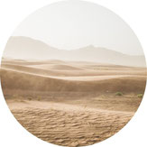 Weite Wüstenlandschaft mit sanften Sanddünen und nebeligem Horizont – Naturaufnahme mit ruhiger Atmosphäre.
