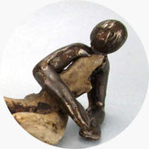 Abstrakte künstlerische Darstellung einer liegenden Frau in Kombination von Treibholz und bronze-farbiger Keramik.