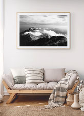 Foto di salotto con divano in legno e stampa fine art in bianco e nero Delphicaphoto con montagne
