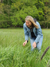 Frau auf Wiese vor Wald
