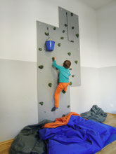 Kind an Kletterwand in Praxis