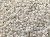 Nahaufnahme PolyesterGranulat PBT. Die 2,5 mm großen Chips sind weiß und kantig.
