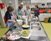 Gruppen von Frauen in einer Schulküche beim Kochen