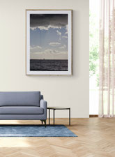 Foto di salotto con divano blu e stampa fine art Delphicaphoto di mare con le nubi