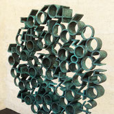 Tobia by Paolo Grassi, large circular bronze sculpture with protruding cylindrical numeric elements