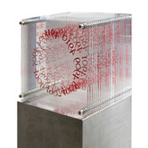 Transparent cube sculpture by Paolo Grassi with layered red numbers suspended in space.