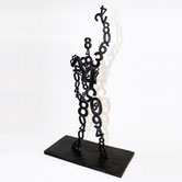 Paolo Grassi – Modulor, upright bronze sculpture with a human silhouette composed of numeric chains.