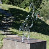 Acrylic sculpture by Paolo Grassi with curving translucent numbers rising in dynamic balance.