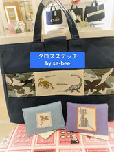 恐竜の刺繍の入った紺色の手提げバッグと動物の刺繍の入ったソフトケース