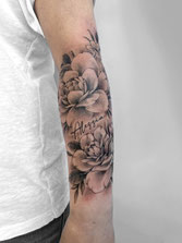 Feines florales Tattoo mit zarten Linien – elegant und detailreich gestochen.