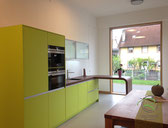 Ausstellungsküche in grün mit drehbarem Tresen von Schreinere Holzdesign Ralf Rapp Geisingen , Arbeitsplatte in Rost-Optik