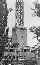 Der betonierte Rundbau des Lagers mit dem Messeturm dahinter (1946).