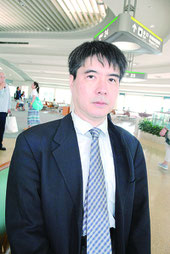 インタビューに答える石井氏=24日午後、那覇空港