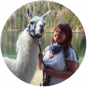 Teilnehmerin bei Tierkommunikation Seminar mit weißen Lama. Hintergrund Langbathsee.