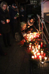 Menschen zünden Kern an am Ort des Terroranschlags Berlin. Foto: Helga Karl