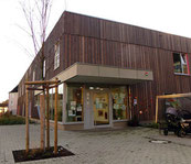Eingangsbereich der Kindertagesstätte Königskinder in Hagen mit moderner Holzfassade und gepflegtem Vorplatz.