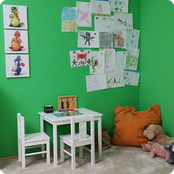 Kinderecke des Behandlungszimmers mit Zeichnungen auf grüner Wand - Heilpraxis M. Dankesreiter, Heilpraktiker Regensburg