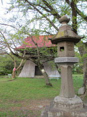 赤い屋根の鐘楼と石灯籠