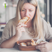 Frau isst gedankenverloren Brot – Symbolbild für emotionales Essen, Stressessen, Frustessen und unbewusstes Essverhalten als Reaktion auf emotionale Auslöser.