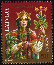 Latvian postage stamp with image of mythological witch Spīdola holding bunches of leaves ad flowers and a red and white folk sash