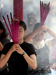 Mädchen mit Rauchkerzen beim Wesak Fest