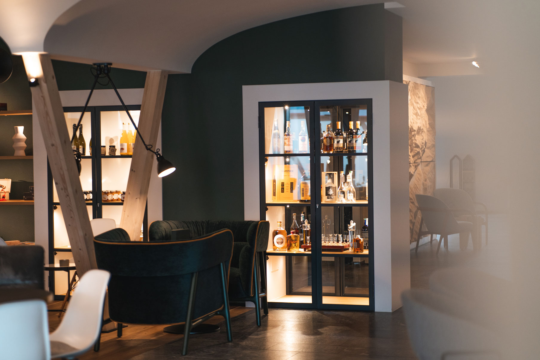 A stylish lounge area at the Garberhof, featuring an illuminated spirits display cabinet and modern décor.