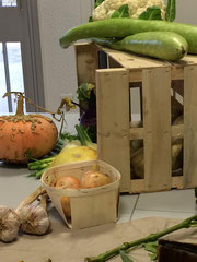 Une composition de nos légumes du marché avec cagette, oignons et courges serpents