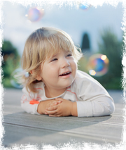 Kleines Mädchen beobachtet Seifenblasen, Glückskinder