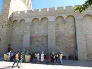 Die Besucher lauschen im Schatten der massiven Kirchenmauer den Ausführungen der Stadtführung